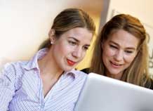 Två kvinnor tittar på en dataskärm